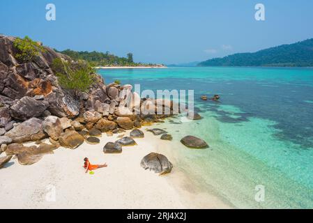 Il viaggiatore asiatico da solo gode di vedute delle acque turchesi del mare sulla spiaggia di Koh KLA durante le vacanze a Ko Lipe, Thailandia. Foto Stock
