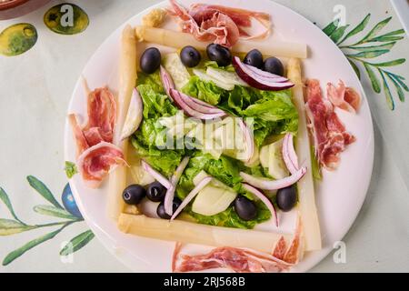 Insalata di lattuga, asparagi, olive nere, prosciutto iberico, cetriolo e cipolla Foto Stock