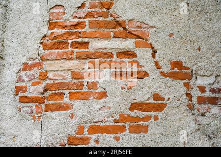 Muro di mattoni rossi con intonaco caduto. Sfondo rustico. Sfondi gruntuosi. Foto Stock