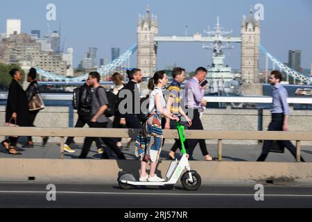 Una donna che guida su uno scooter elettrico Lime parte del programma di noleggio di scooter elettrici Transport for London, attraverso, durante l'ora di punta serale. , Londra, Regno Unito. 7 giu Foto Stock