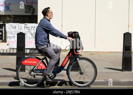 Un uomo che pedala lungo Whitehall, su un Transport for London Santander Cycles noleggia una bicicletta, comunemente nota come «Boris Bike». Whitehall, Londra, Regno Unito. 7 Foto Stock