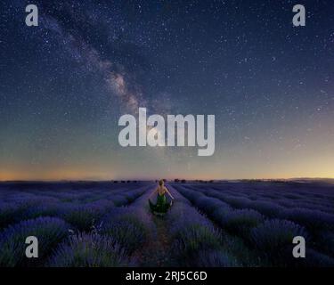 donna al crepuscolo in un cielo di strega di lavanda con via lattiginosa Foto Stock