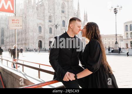 Un uomo e una donna eleganti che amano baciarsi vicino alla stazione della metropolitana Duomo di Milano Foto Stock