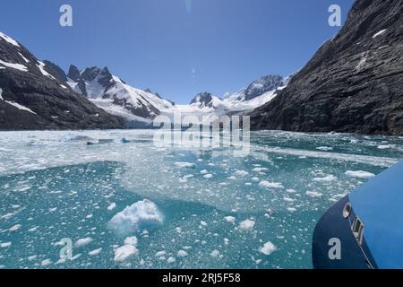 Prua di una nave da spedizione - montagne coperte di ghiaccio e neve galleggianti sull'isola della Georgia del Sud, fiordo di Drygalski - crociera di spedizione in Antartide Foto Stock
