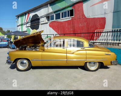 Vecchia strada Buick Super Deluxe Dynaflow 1950 dorata. Aprire il cofano che mostra il motore. Vista laterale. Mostra di auto d'epoca Expo Fierro 2023. Giornata di sole Foto Stock