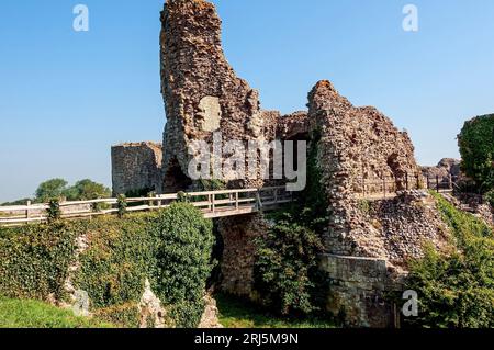 Le rovine del castello di Pevensey sono raggiunte attraversando un ponte di legno sopra il fossato Foto Stock