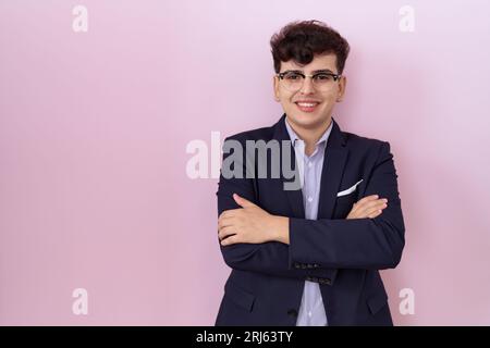 Giovane uomo non binario con barba e cravatta faccia felice sorridente con braccia incrociate che guardano la fotocamera. persona positiva. Foto Stock