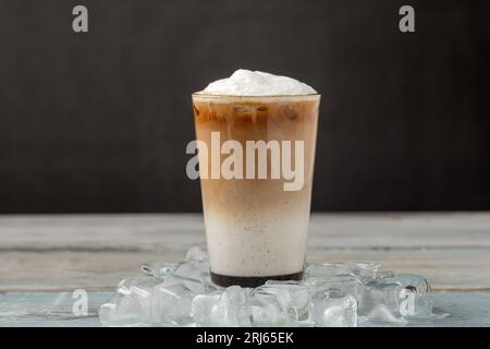 Caffettiera ghiacciata in tazza di vetro su un tavolo di legno Foto Stock