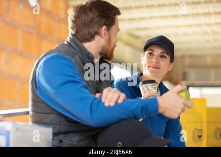 i costruttori maschi e femmine hanno una pausa di lavoro Foto Stock