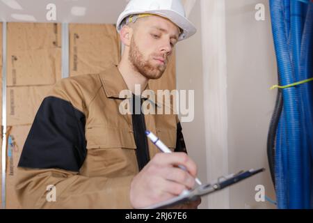 ispettore edile che guarda i tubi di nuova proprietà Foto Stock