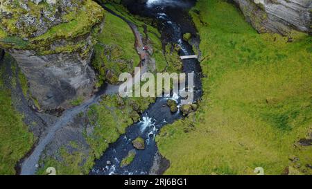 Un paesaggio maestoso caratterizzato da una cascata che scende lungo lussureggianti colline verdi Foto Stock