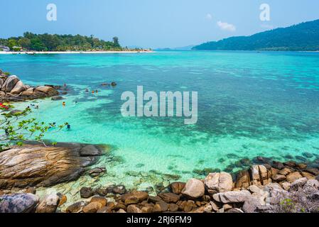 Piccola isola di Koh KLA con un gruppo di persone (irriconoscibili) che fanno snorkeling. Ko Lipe (sinistra) e Ko Adang (destra) all'orizzonte. Foto Stock