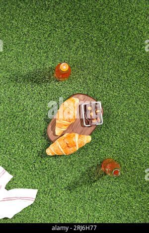 Vista dall'alto di un picnic sull'erba con croissant e altri dolci Foto Stock