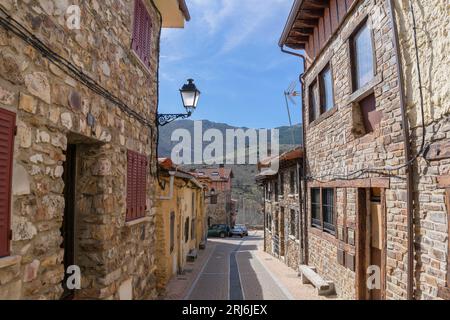 PUEBLA DE LA SIERRA, MADRID. Strade strette e case in pietra in una soleggiata giornata estiva nel villaggio medievale di Puebla de la Sierra, Madrid, Spagna Foto Stock