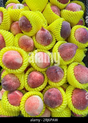 Un mucchio di pesche fresche in un mercato all'aperto Foto Stock