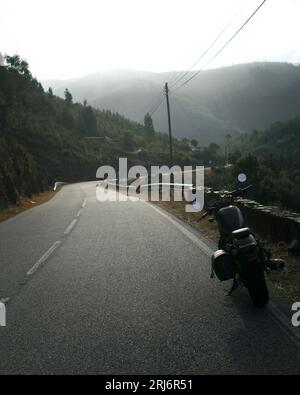 La motocicletta è parcheggiata sul lato della strada di montagna. Moto in viaggio. Foto Stock