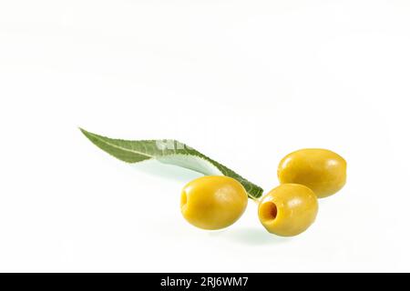 Primo piano con tre olive verdi su sfondo bianco. Foto Stock