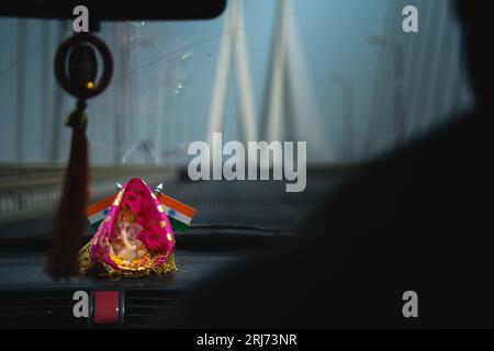 Una piccola statua del dio indù Ganesh sul cruscotto di un'auto in India. Foto Stock