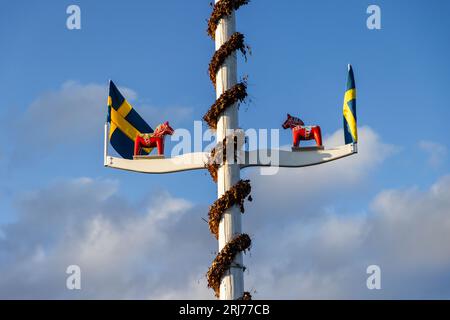 Bandiere svedesi e cavalli dalecarliani/ cavalli dala su un'asta di legno, villaggio di Nusnäs, contea di Dalarna, Svezia. Foto Stock