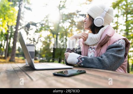 Freelance che lavora su un notebook nel parco autunnale. Foto Stock
