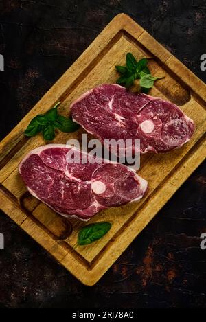 Costolette di agnello presentate con gli ingredienti sul tavolo Foto Stock