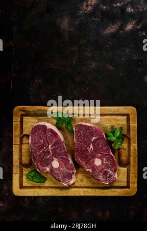 Costolette di agnello presentate con gli ingredienti sul tavolo Foto Stock