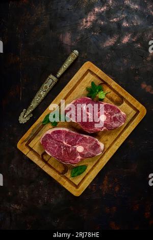 Costolette di agnello presentate con gli ingredienti sul tavolo Foto Stock