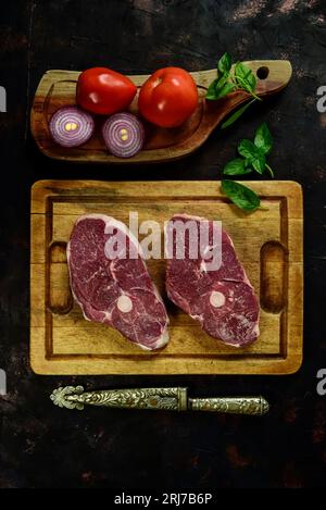 Costolette di agnello presentate con gli ingredienti sul tavolo Foto Stock