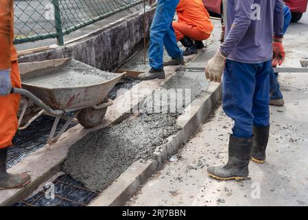 Salvador, Bahia, Brasile - 11 agosto 2023: I lavoratori edili stanno riparando un marciapiede dell'Avenida Tancredo Neves a Salvador, Bahia, Foto Stock