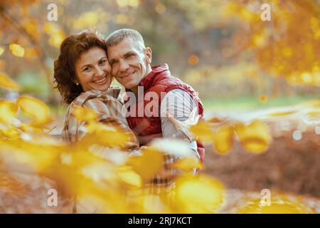 Ciao autunno. Ritratto di una coppia moderna sorridente nel parco che abbraccia. Foto Stock
