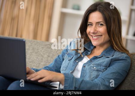 giovane donna millenaria che lavora su un notebook da casa Foto Stock