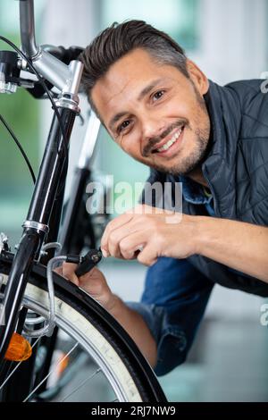 ritratto di un uomo che chiude la sua bicicletta Foto Stock