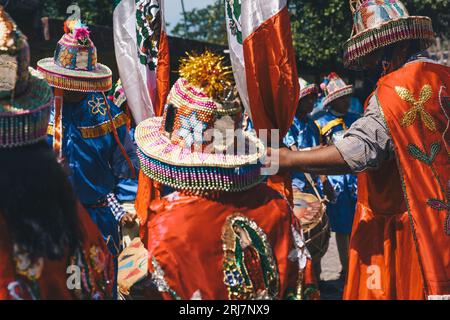 Sfilata multicolore di individui provenienti da comunità indigene, in un festival popolare a Suchitlán, Colima, Messico. Foto Stock