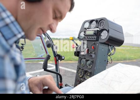 Maschio ingegnere aero con appunti lavora nel cockpit in elicottero Foto Stock