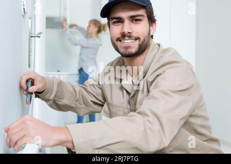 il giovane ripara il primo piano del radiatore di riscaldamento Foto Stock