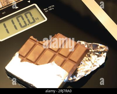 barretta di cioccolato su scala elettronica, foto concettuale Foto Stock