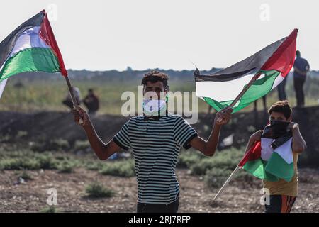 Gaza, Gaza, Palestina. 21 agosto 2023. Un ragazzo palestinese tiene bandiere palestinesi a una marcia sul confine della Striscia di Gaza (immagine di credito: © Saher Alghorra/ZUMA Press Wire) SOLO USO EDITORIALE! Non per USO commerciale! Foto Stock