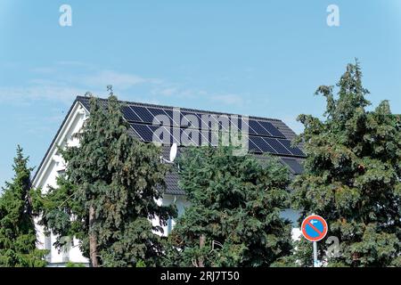 Aumento dei costi dell'elettricità e autoproduzione di elettricità, tetto della casa con elementi fotovoltaici Foto Stock