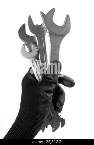 La mano dell'uomo in un guanto da lavoro tiene una chiave isolata su sfondo bianco Foto Stock