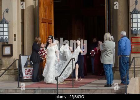 Una sposa appena sposata e la sua festa di nozze partono dalla basilica cattedrale di San Francesco d'Assisi dopo un matrimonio a Santa Fe, New Mexico. Foto Stock