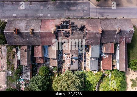 Vista aerea direttamente sopra una casa terrazzata con tetto danneggiato dopo un incendio Foto Stock