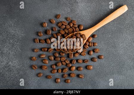 Cucchiaio in legno con chicchi di caffè tostati, vista dall'alto Foto Stock