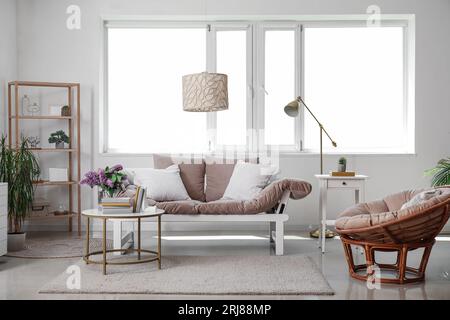 Interno del soggiorno con divano, poltrona ed elegante supporto per libri su tavolino da caffè Foto Stock