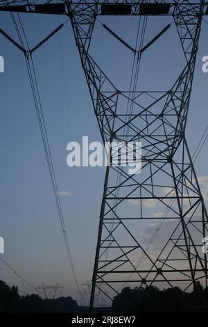 Linee elettriche ad alta capacità o linee elettriche che trasportano elettricità negli Stati Uniti contro un cielo parzialmente nuvoloso. Foto Stock