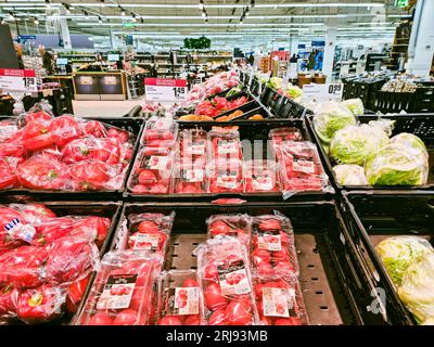 WETZLAR, HESSE, GERMANY 12-21-2022: Pomodori freschi e succosi, paprica e lattuga confezionati su un tavolo di vendita in un negozio di alimentari. Foto Stock