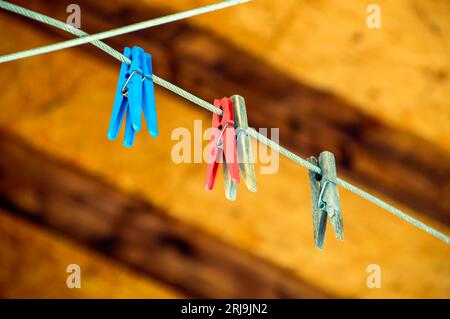 Concepire l'amore e la comunita' senza persone. clothespins su una corda su uno sfondo di legno. clothespin centrale a fuoco Foto Stock