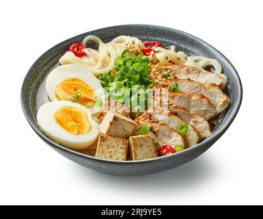 ciotola di zuppa di noodle asiatiche di ramen con pollo, uova e tofu isolati su sfondo bianco Foto Stock