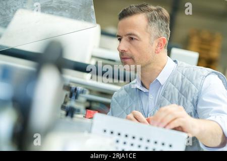 ingegnere di fabbrica che utilizza una macchina Foto Stock