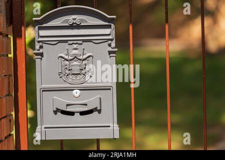 Primo piano di una cassetta postale italiana grigia metallica appesa al cancello di una villa, Liguria, Italia, Europa. Foto Stock