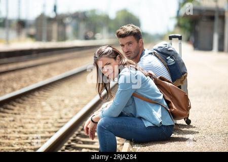 coppia in attesa su una piattaforma ferroviaria Foto Stock